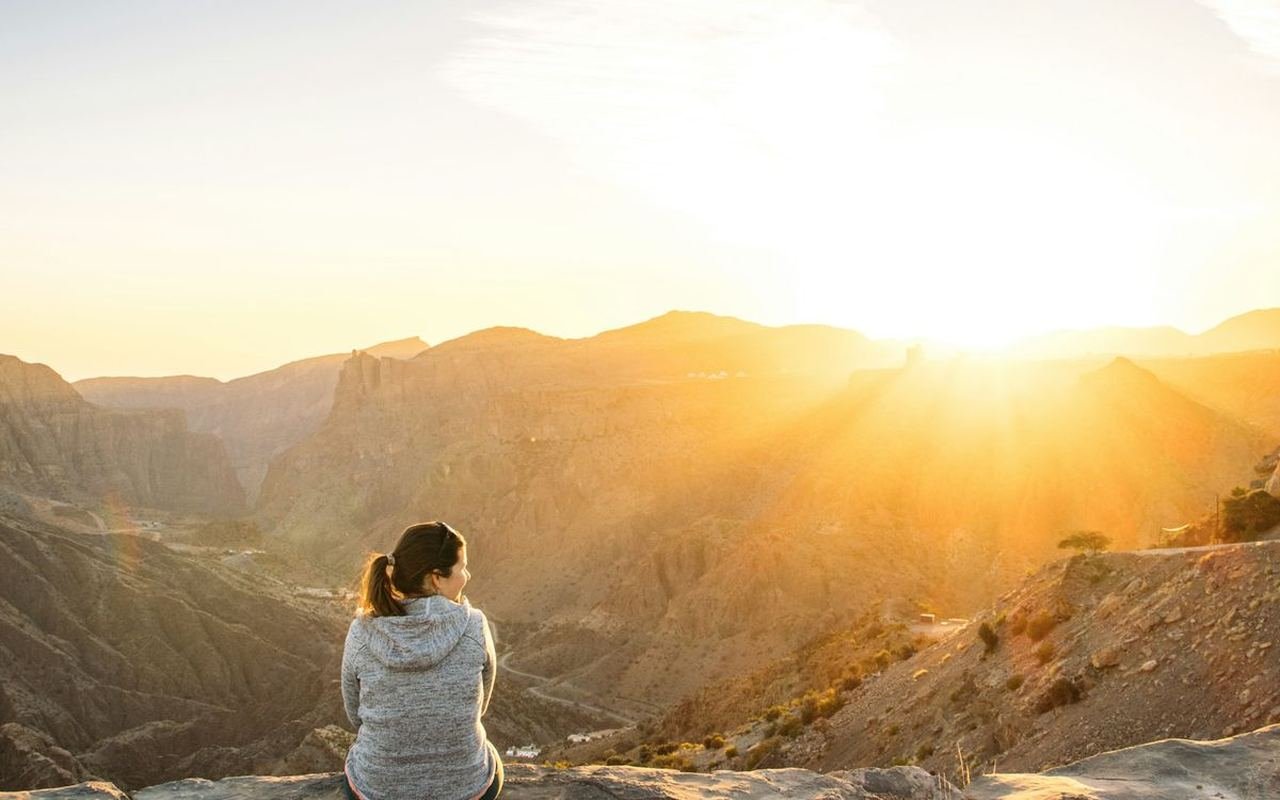 Visitor watching the sunrise over the canyons